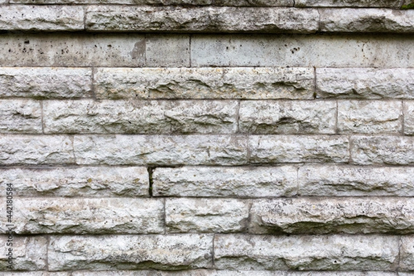 Fototapeta Old stone wall made of gray tiles. Rough surface texture