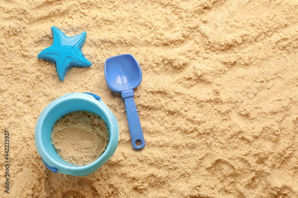 Fototapeta Flat lay of beach toy kit on sand, space for text. Outdoor play