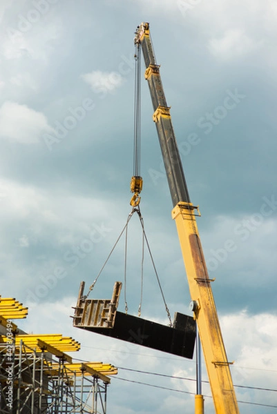 Fototapeta Truck crane lifts the formwork on the scaffolding
