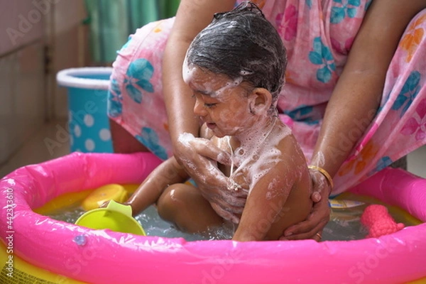 Fototapeta indian baby boy enjoying bath in an inflatable pool