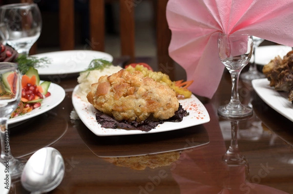Fototapeta Kiev cutlet made of meat fried in breadcrumbs with a side dish of rice is on the banquet table