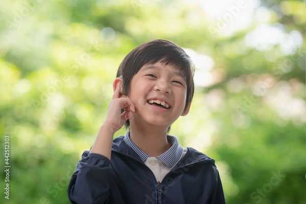 Obraz Asian child with hearing aid on nature background
