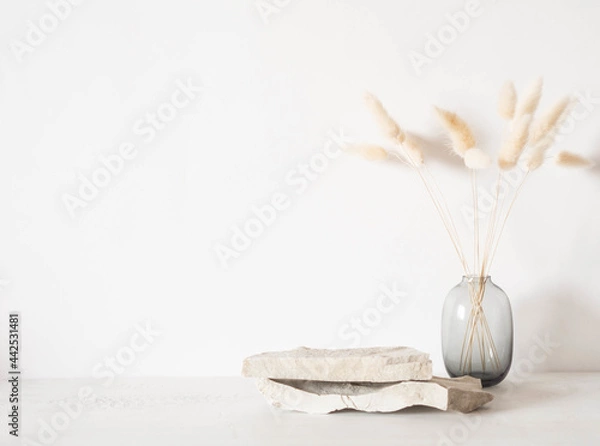 Fototapeta Grey natural stones podium on white background, platform for product display and dry branches in vase