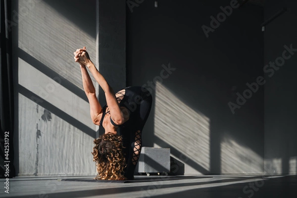 Obraz Young woman practicing yoga poses in an urban background on sunny day