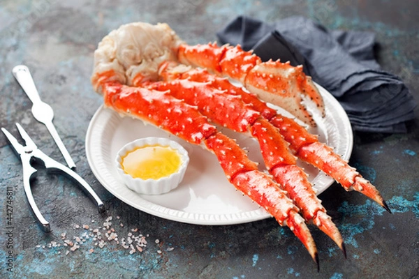 Obraz Red king crab legs with butter sauce on a plate, selective focus