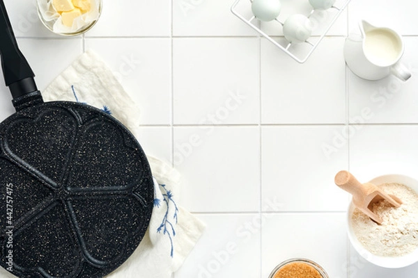 Fototapeta Empty frying pan black, skillet with stone nonstick coating for baking pancakes in shape of breakfast hearts and ingredients on gray concrete table background. Breakfast for Valentines Day. Top view.