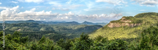 Fototapeta Sunlight dapples the vista from the Big View Scenic Overlook along Highway 64 between Cashiers and Highlands, North Carolina in Nantahala National Forest. Whiteside Mountain is to the right.