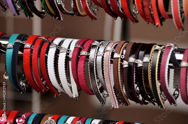 Fototapeta Leather multi-colored bracelets hang in a row on the window of a souvenir shop for tourists. Russia Kazan 24.04.2021. High quality photo
