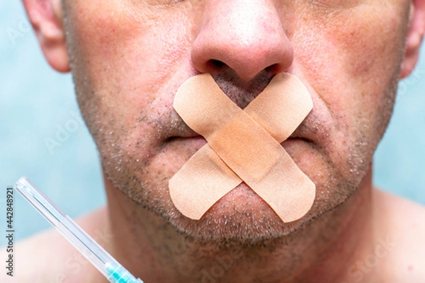 Obraz the concept of universal vaccination and freedom of speech a person's mouth is sealed with a medical plaster next to a syringe for injection