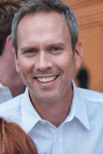 Fototapeta Middle aged man smiling in a crowd