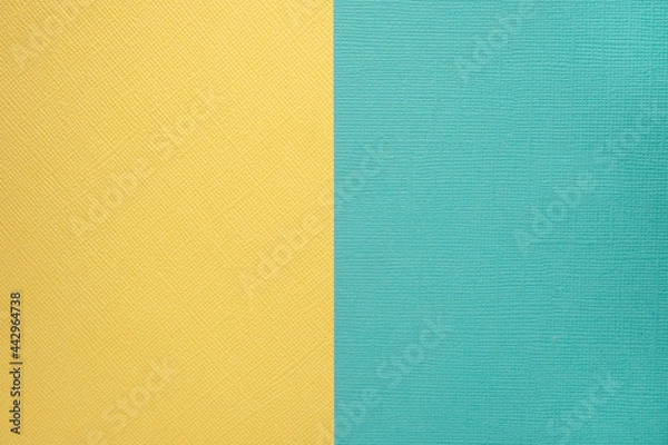Fototapeta Two colored papers with a blue and yellow overlay on the floor. they divide half of the image. Dual background, flat lay. High quality photo