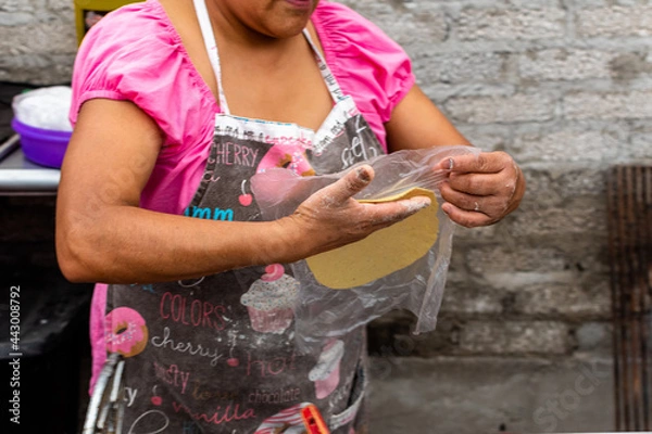 Fototapeta woman's hands making a tortilla in a typical way