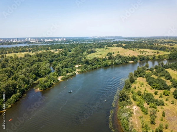 Fototapeta River among green trees in summer. Aerial drone view.