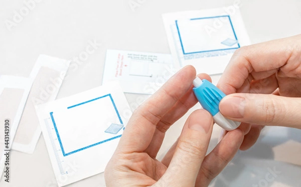Fototapeta Person using small blood test at home, personal rapid health care kit with hygiene care. Clean equipment for quick sample result of diagnostic.