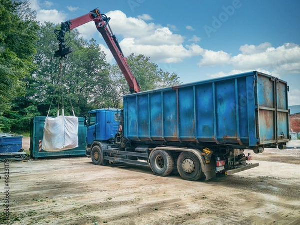 Obraz Crane truck with garbage bag on a recycling yard.