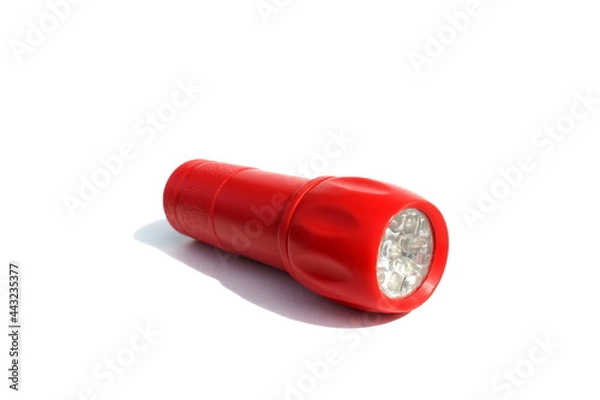 Fototapeta Red flashlight lies on a white background