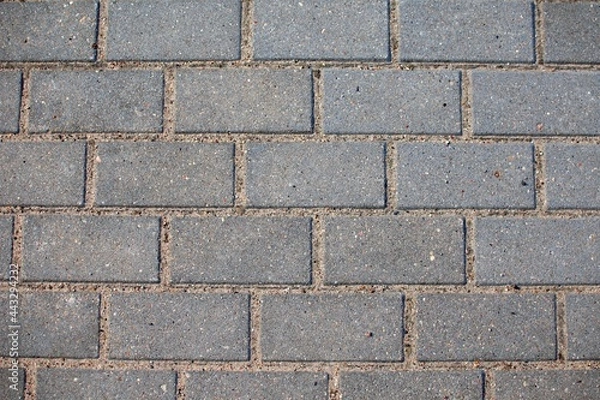 Fototapeta Gray, pavement cobblestones arranged symmetrically.