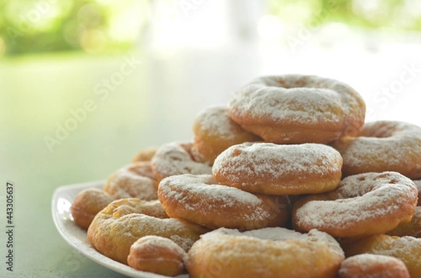 Fototapeta pile of donuts with powdered sugar topping with beautiful blurred background