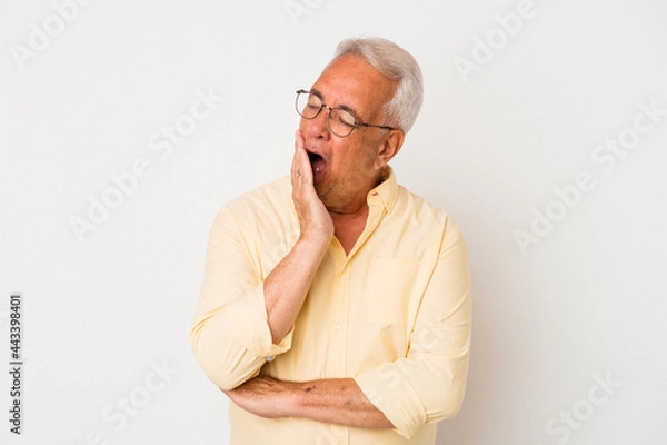 Fototapeta Senior american man isolated on white background yawning showing a tired gesture covering mouth with hand.