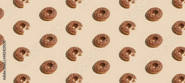 Obraz Creative summer vibes concept with fresh brown chocolate doughnuts on pastel bright beige background. Geometric pattern composition, sweet dessert idea.