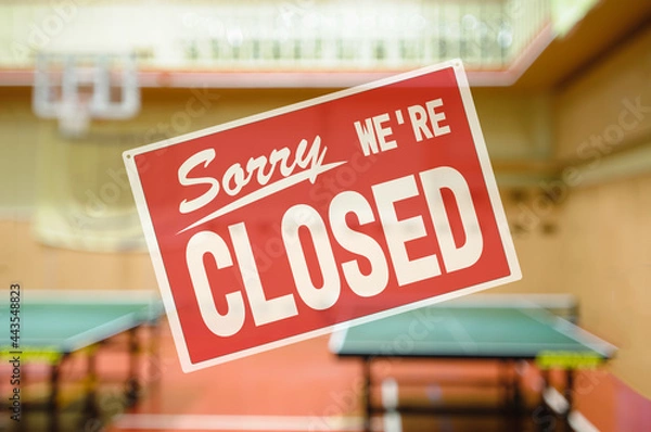 Obraz inscription sorry we are closed. introducing forbidden measures for attending group classes. Naturally blurred interior of modern gym with tables for ping-pong