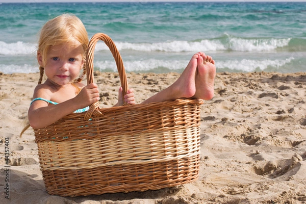 Fototapeta Маленькая девочка сидит в корзинке