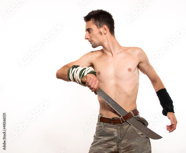 Obraz Young fighter holding a machete