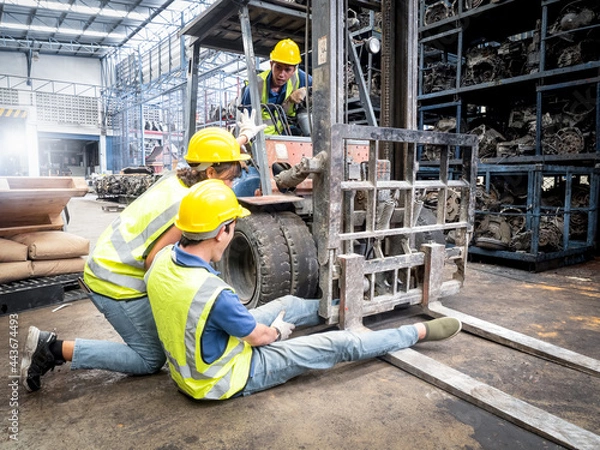 Fototapeta Female workers are banning cargo drivers from continuing to drive due to an accident, a male worker's leg gets stuck in a forklift's wheel while working inside an auto-parts warehouse.