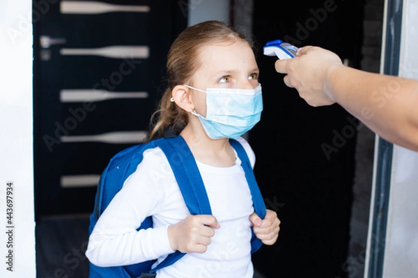 Obraz Little girl is going back to school with the mask on her face