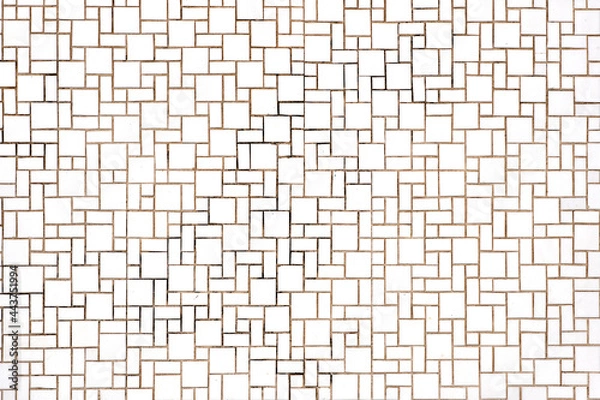 Fototapeta Background from a wall made of rectangular and square white mosaic tiles