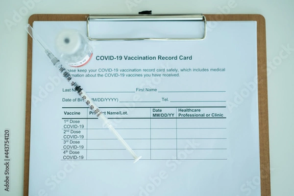 Fototapeta COVID-19 or coronavirus vaccine in a bottle and needle with the COVID-19 vaccination record document.