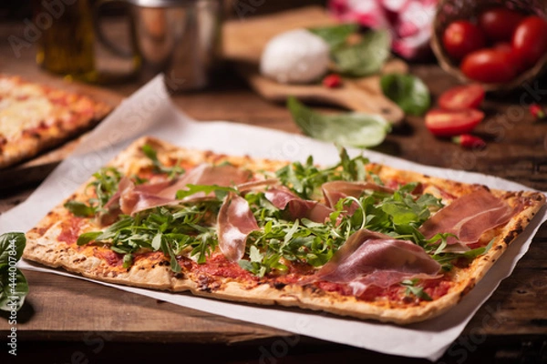 Fototapeta Italian Focaccia with rucola rocket arugula on rustic table.