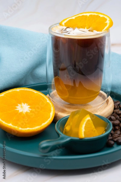 Fototapeta Iced americano black coffee and a layer of orange juice.