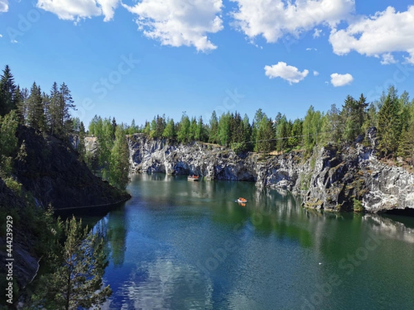 Fototapeta View from the observation deck of the emerald water of the Marble Canyon in the Ruskeala Mountain Park with the reflection of the sky and clouds on a sunny summer day.