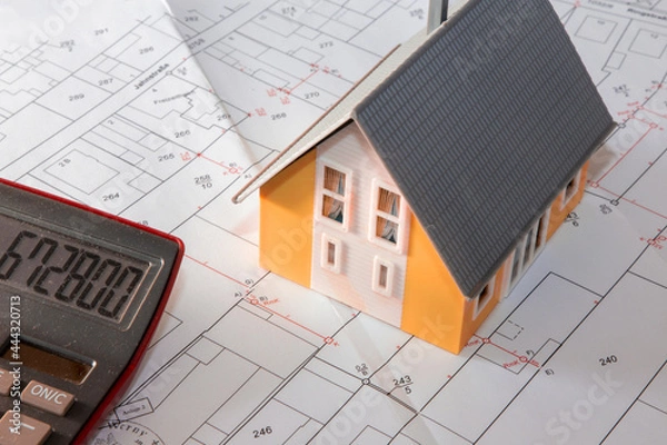 Obraz Symbolbild Bauen: Modelhaus auf einem Bebauungsplan