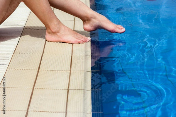 Fototapeta beautiful legs of a girl near a swimming pool on the sea background