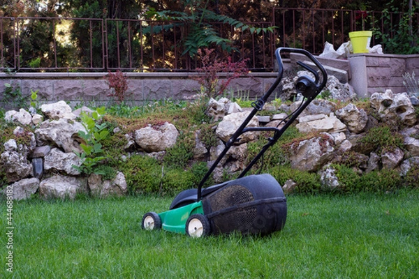 Obraz small lawn mower on the grass.