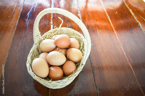 Obraz eggs in a basket on wooden table