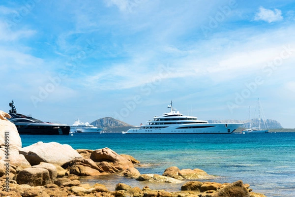 Obraz Stunning view of some luxury yachts sailing on a turquoise water during a sunny day. Cala di volpe bay,Sardinia, Italy