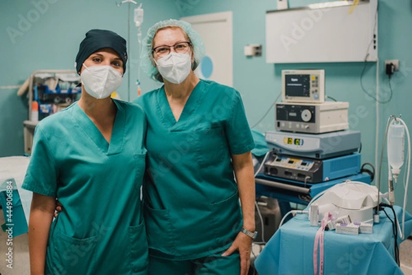 Fototapeta Portrait of medical nurses looking at camera inside operating theater at private clinic - Focus on right doctor face