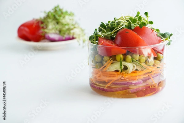 Obraz A snack of raw vegetables in a glass. Bright vegetables on a white background