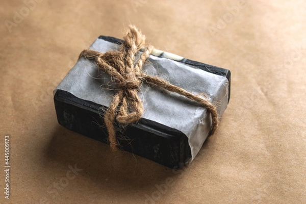 Obraz A block of natural carbon soap on craft paper