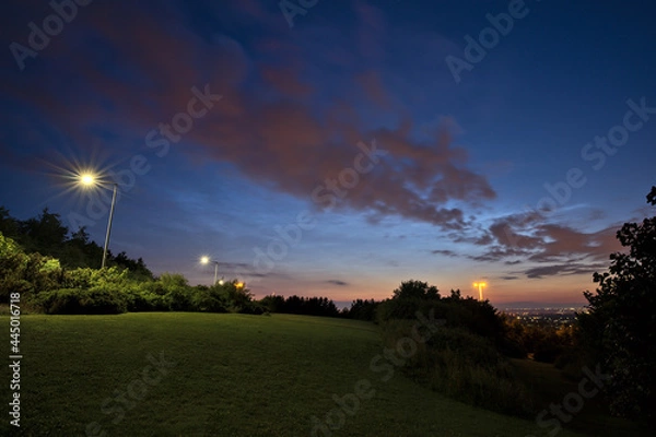 Fototapeta Beautiful wide angle view of very rare noctilucent clouds and common clouds seen in Dublin, Ireland on July 12, 2021 a half of hour before midnight. Details of NLC. Night shining clouds. Crescent Moon