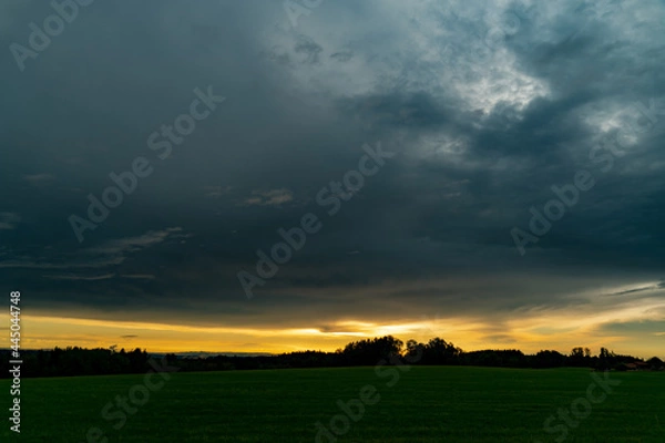 Fototapeta sunset over field, dark clouds, cloud cover, thunderstorm