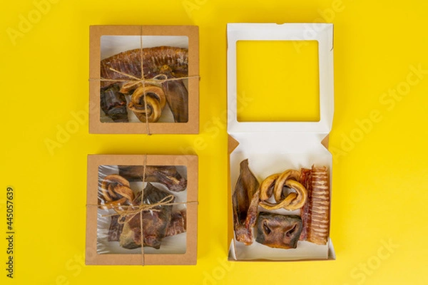 Obraz Kit of dried meat treats for training and encouraging dogs in recyclable eco-friendly cardboard boxes, top view, yellow background, copy space.