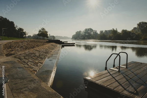Fototapeta place for people meeting or gathering place in a city on a river with wooden platform and handrails