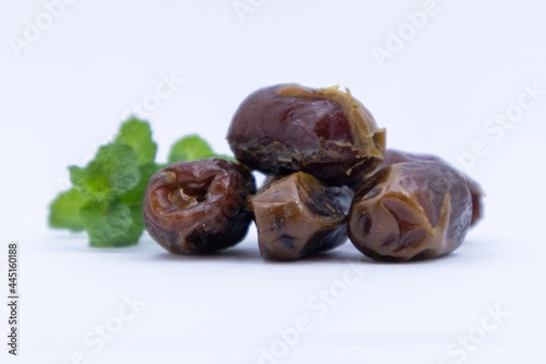 Fototapeta pile of dates with green leaf garnish
