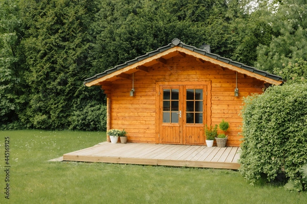 Fototapeta  flowers in front of a wooden hut. Garden joy in summer. Relax in the garden and enjoy the beautiful weather. Lavender and hydrangea in pot next to a garden shed 