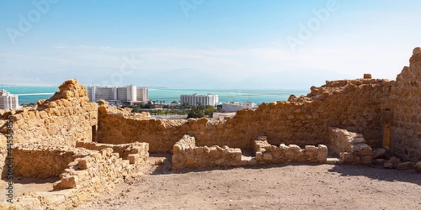Obraz an ancient roman fortress sits on a hill above the modern resort town of Ein Bokek on the Dead Sea in Israel with Jordan in the far background