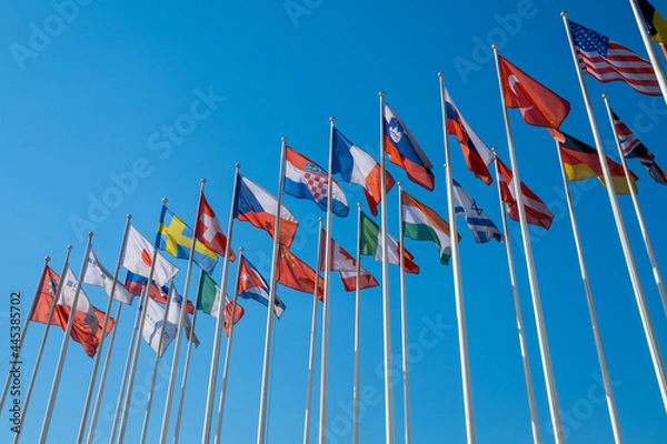 Obraz Different flags fluttering on flagpoles